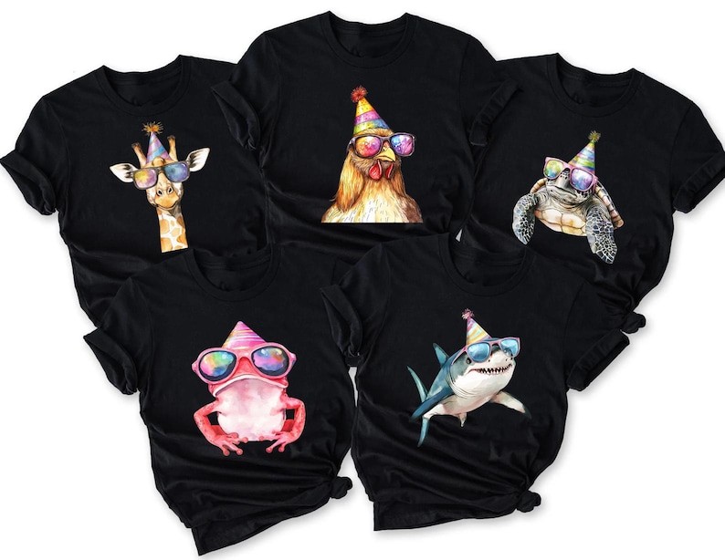 May include: Five black short-sleeve t-shirts, each featuring a different animal wearing a colorful party hat and rainbow-tinted sunglasses. The animals include a giraffe, a chicken, a turtle, a pink frog, and a shark, all rendered in a vibrant, artistic style.