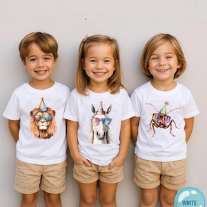 May include: Three white t-shirts featuring graphic prints of a lion, a horse, and a cockroach, each wearing a colorful party hat and rainbow-tinted sunglasses. The shirts are paired with tan shorts, creating a coordinated set of casual clothing.