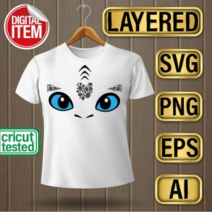 May include: White t-shirt with a blue and gray dragon face graphic. The graphic is layered and includes the text "LAYERED", "SVG", "PNG", "EPS", and "AI".