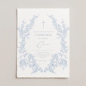 May include: A light blue floral wreath frames a Communion invitation on textured paper. The invitation includes the text "Please join us for the Communion of our son" and event details. A cross is at the top of the invitation.