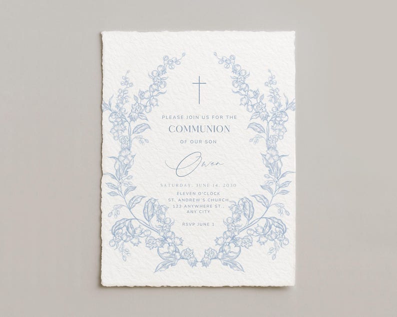 May include: A light blue floral wreath frames the text on a white invitation. The invitation reads "Please join us for the Communion of our son Owen" with event details. The paper has a textured, deckled edge.