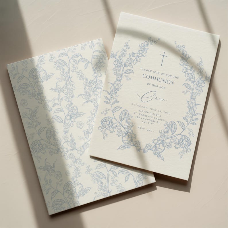 May include: Two cream-colored Communion invitations with blue floral designs. One invitation is open, displaying text within a floral wreath, including "PLEASE JOIN US FOR THE COMMUNION OF OUR SON" and the name "Owen". The other invitation shows a floral pattern.