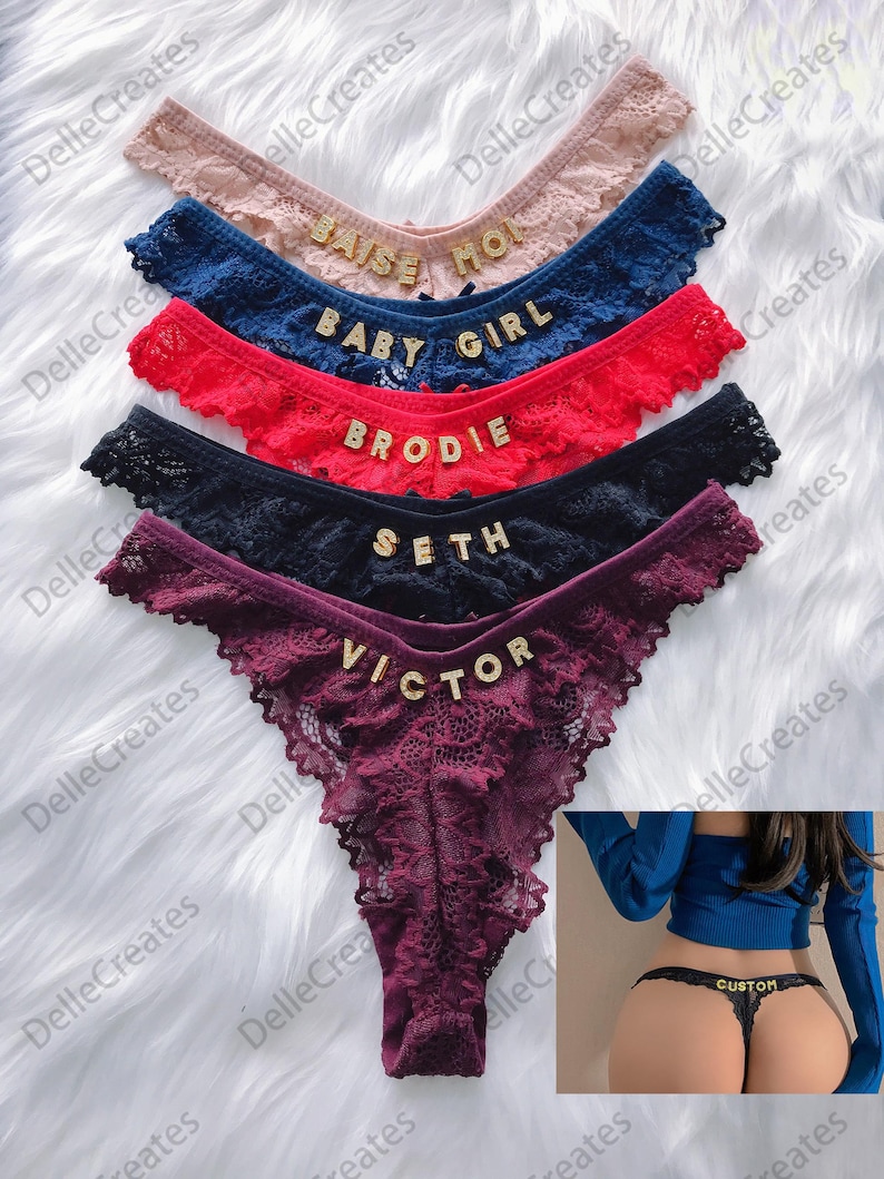 May include: A set of six lace underwear with different names embroidered on them in gold letters. The names are "Baise Mon", "Baby Girl", "Brodie", "Seth", "Victor", and "Custom".