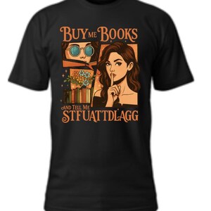 May include: Black t-shirt with a graphic design featuring the text "BUY ME BOOKS AND TELL ME STFUATTDLAGG". The design includes illustrations of a person wearing glasses and a woman with a finger to her lips.