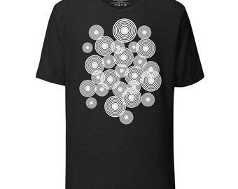 Può includere: T-shirt nero con un motivo a cerchi concentrici bianchi. I cerchi variano in dimensioni e si sovrappongono, creando un motivo dinamico. La maglietta ha un girocollo e maniche corte.