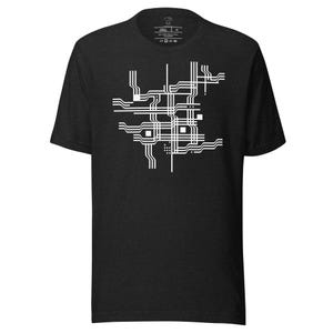 May include: Dark gray t-shirt featuring a white geometric design. The design consists of interconnected lines, squares, and rectangles, creating an abstract pattern. The shirt has a crew neck and short sleeves.