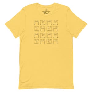 May include: A yellow t-shirt with a black outline of a floppy disk repeated across the front of the shirt.