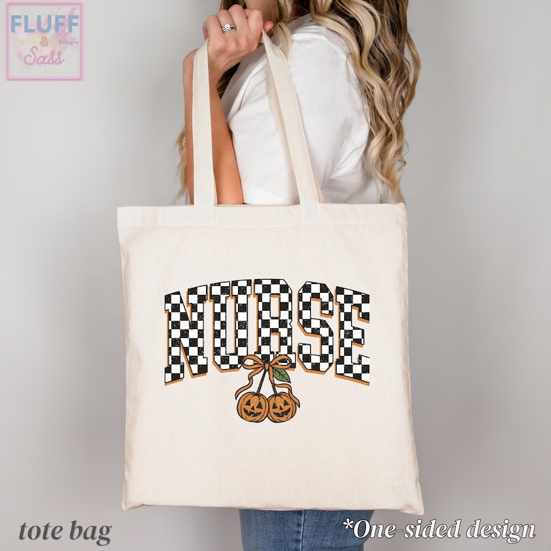 Puede incluir: Un bolso de tela color crema con la palabra NURSE en un patr&oacute;n de cuadros blanco y negro. Debajo del texto, hay un gr&aacute;fico de dos calabazas naranjas tipo jack-o'-lantern conectadas por un tallo con una hoja verde y un lazo marr&oacute;n.