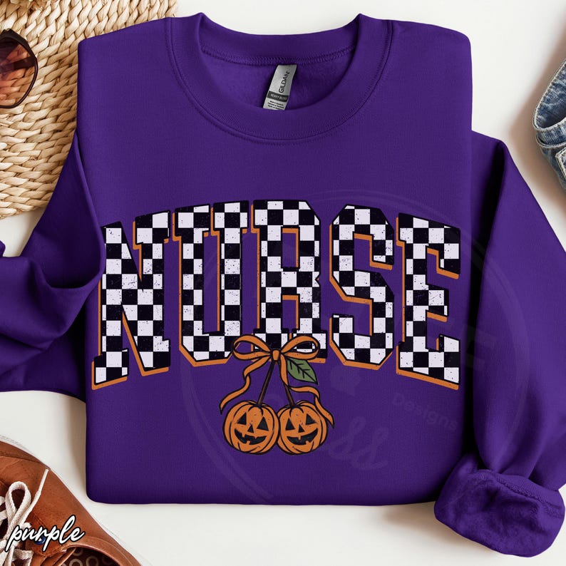 Puede incluir: Una sudadera morada de cuello redondo con la palabra NURSE en un patr&oacute;n de cuadros blancos y negros. Debajo del texto, hay un gr&aacute;fico de dos calabazas naranjas tipo linterna conectadas por un tallo con un lazo y una hoja verde.