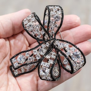 Broche de lazo grande vintage de Kenneth Jay Lane: broche de cristal de estrás 3D, joya plateada, estilo de diseño, impecable.