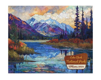 Op de afbeelding: Een kleurrijke landschapsafdruk van Lake Clark National Park. Het kunstwerk toont een bergketen, een meer en bomen, met de tekst "Lake Clark National Park Wilsons 2024" op een houten bord.