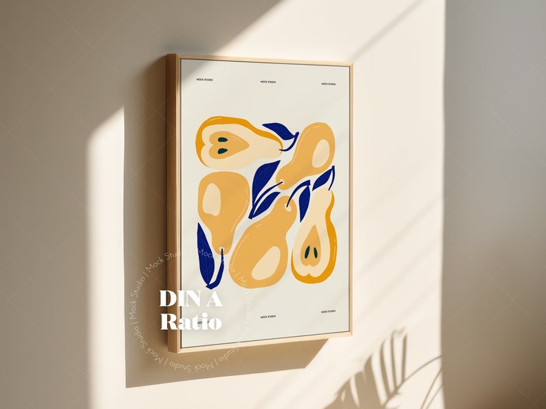 May include: A framed print with a minimalist design featuring yellow pears with blue leaves on a white background. The frame is light wood and the print is titled "DIN A Ratio".