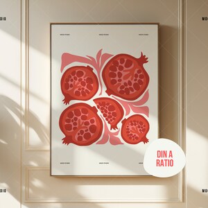 K&ouml;nnte beinhalten: Ein gerahmter Druck mit einem minimalistischen Design, das f&uuml;nf rote Granat&auml;pfel auf wei&szlig;em Hintergrund zeigt. Der Druck hat den Text "Din A Ratio" in einem wei&szlig;en Kreis unten rechts.