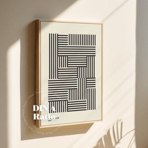 May include: A framed black and white geometric print with a wooden frame. The print features a pattern of horizontal and vertical lines.
