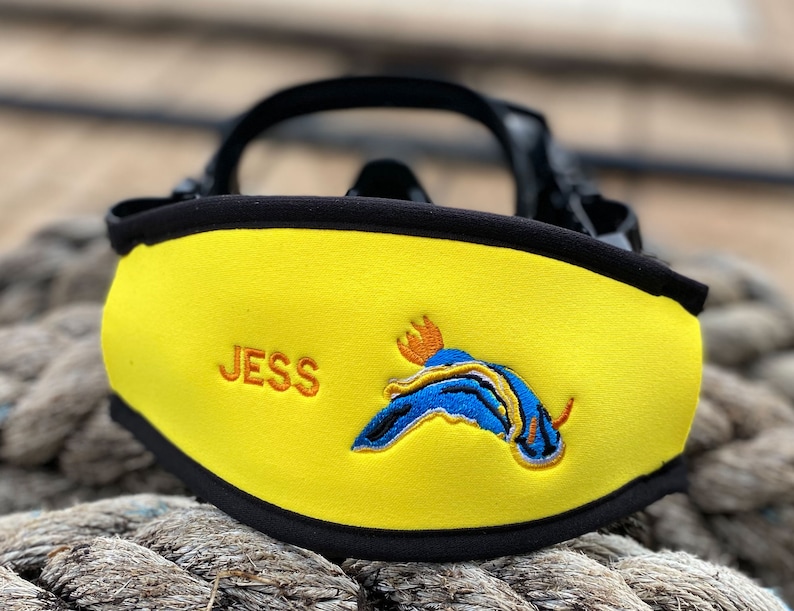 Yellow neoprene scuba mask strap with black trim and a blue and orange embroidered sea slug design. The strap is personalized with the name "JESS".