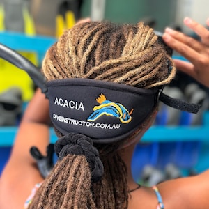 A black neoprene headband with the text "ACACIA diveinstructor.com.au" and a blue and yellow sea slug design.