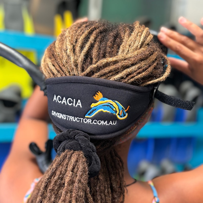 A black neoprene headband with the text "ACACIA diveinstructor.com.au" and a blue and yellow sea slug design.