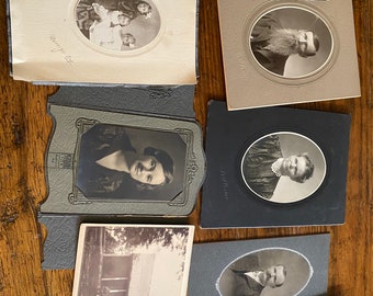 May include: A collection of vintage black and white photographs in oval and rectangular frames. The photos depict families, individuals, and a house.