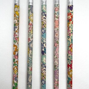 May include: Five wooden pencils with different floral patterns and silver-colored erasers. The pencils are labeled 49, 50, 51, 52, and 53.