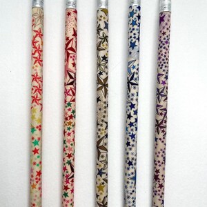 May include: Five wooden pencils with different star patterns. The pencils are labeled 44, 45, 46, 47, and 48. The pencils have a white background with colorful stars.