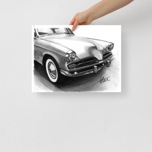 Könnte beinhalten: Eine Schwarzweiß-Bleistiftzeichnung eines Oldtimers. Das Auto ist ein Studebaker aus den 1950er Jahren, und die Zeichnung konzentriert sich auf die Vorderseite des Autos, die den verchromten Kühlergrill und die Scheinwerfer zeigt.