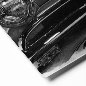 Könnte beinhalten: Schwarz-Weiß-Illustration eines Scheinwerfers und der Karosserie eines Oldtimers. Das Bild zeigt die geschwungenen Chromverzierungen, den Blinker und den runden Scheinwerfer. Das Kunstwerk ist detailliert und fängt die Reflexionen auf der Oberfläche des Autos ein.