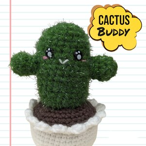 May include: A handmade green cactus plushie with a smiling face, arms, and a white and brown pot. The text "CACTUS BUDDY" is in a yellow speech bubble. The cactus has a sparkly texture.