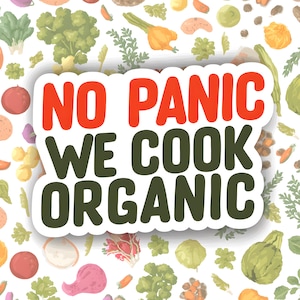 May include: A white sticker with the text "NO PANIC WE COOK ORGANIC" in red and green, surrounded by illustrations of various vegetables. The background is a pattern of colorful vegetables.