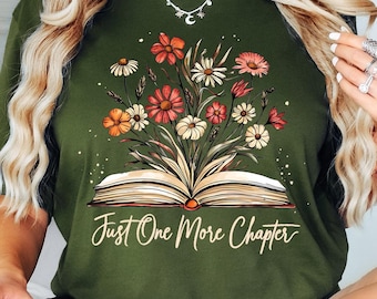 May include: A green t-shirt with a floral design and an open book with the text "Just One More Chapter".