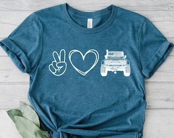 May include: A teal blue t-shirt with a white peace sign, heart, and a jeep graphic. The text "Peace Love Jeep" is printed on the shirt.