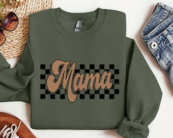 May include: A green sweatshirt with a brown retro-style "Mama" graphic on a black and white checkered background.