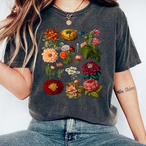May include: A dark gray t-shirt with a vintage floral print featuring a variety of flowers in shades of red, orange, yellow, pink, and white.