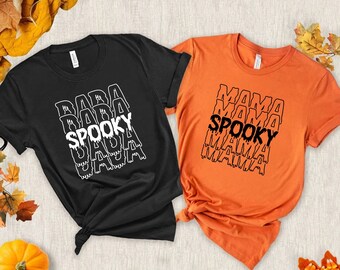 May include: Two black and orange t-shirts with the text "Baba Spooky" and "Mama Spooky" printed on them. The text is in a dripping font style.