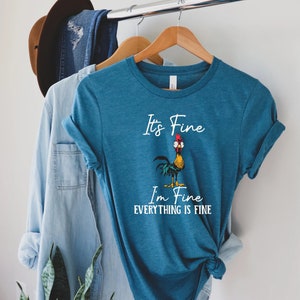 May include: A teal blue t-shirt with a white rooster graphic and the text "It's Fine I'm Fine Everything Is Fine".