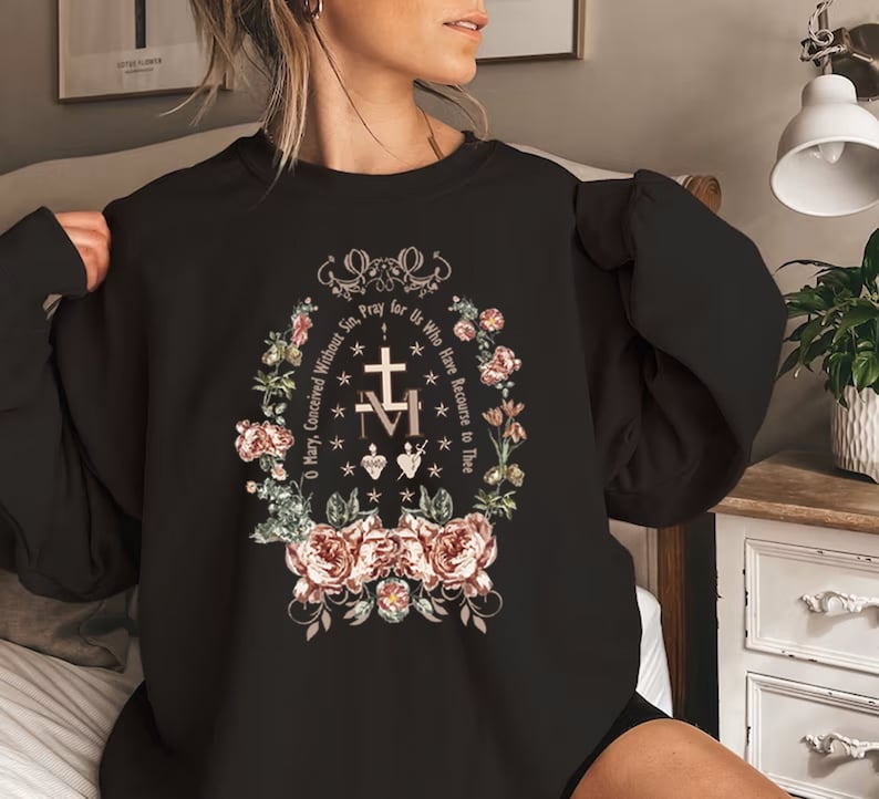 May include: Black sweatshirt with a floral design and the text "O Mary, Conceived Without Sin, Pray for Us Who Have Recourse to Thee."