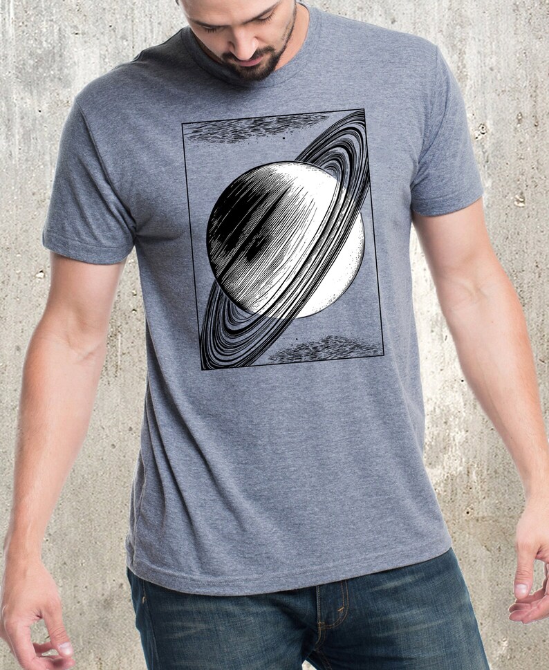 May include: A heather grey t-shirt with a black and white illustration of Saturn with its rings.
