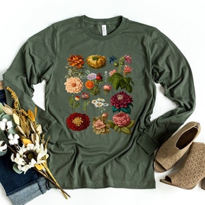 May include: A long-sleeved, olive green t-shirt with a vintage floral print featuring a variety of flowers in shades of red, pink, orange, yellow, and white.