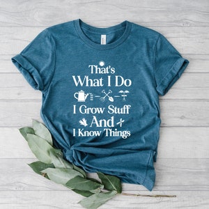 May include: A teal blue t-shirt with white text that reads "That's What I Do I Grow Stuff And I Know Things". The text is surrounded by gardening-themed icons.