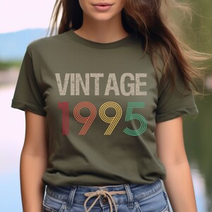May include: A green t-shirt with the text "Vintage 1995" in a retro font with red, yellow, and green stripes.