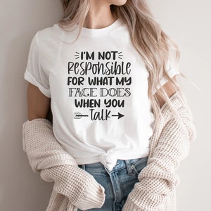 K&ouml;nnte beinhalten: Wei&szlig;es T-Shirt mit schwarzem Text, der "Ich bin nicht verantwortlich f&uuml;r das, was mein Gesicht tut, wenn du sprichst" lautet, mit einem schwarzen Pfeil, der nach rechts zeigt.