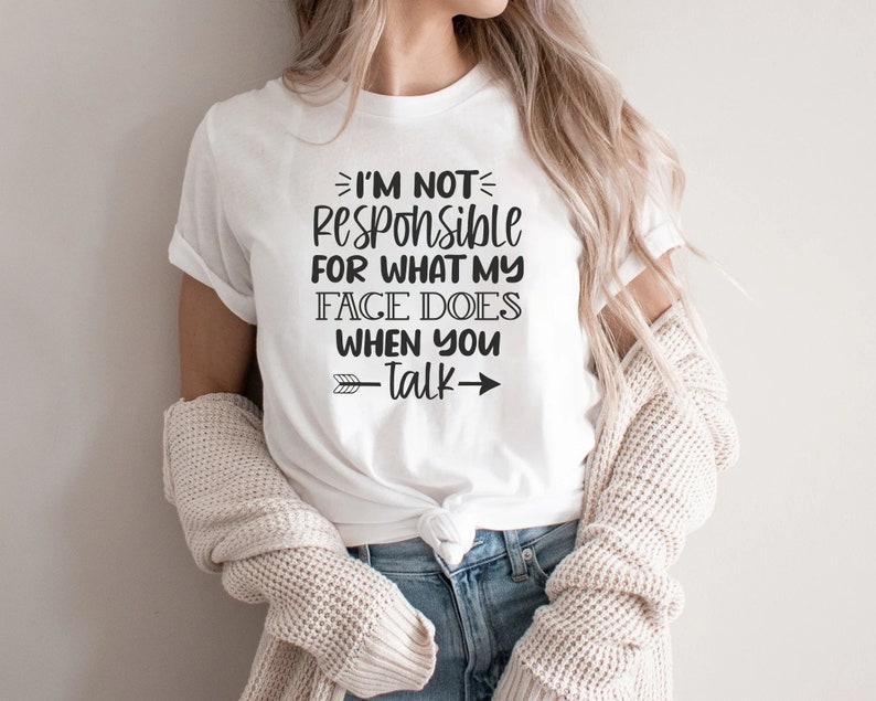 K&ouml;nnte beinhalten: Wei&szlig;es T-Shirt mit schwarzem Text, der "Ich bin nicht verantwortlich f&uuml;r das, was mein Gesicht tut, wenn du sprichst" lautet, mit einem schwarzen Pfeil, der nach rechts zeigt.
