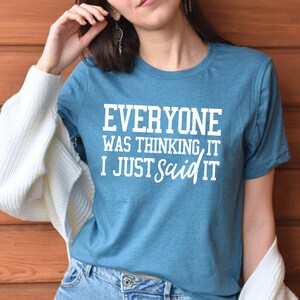 Pu&ograve; includere: Una maglietta blu turchese con testo bianco che recita "Everyone was thinking it I just said it".
