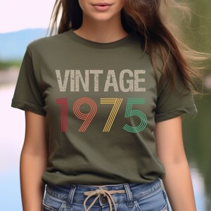 May include: A green t-shirt with the text "Vintage 1975" in a retro font with colorful stripes.