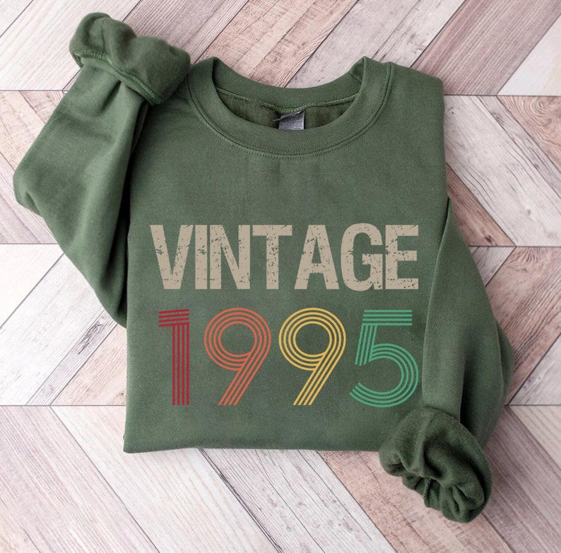 May include: A green sweatshirt with the text "Vintage 1995" in a retro, multi-colored font.