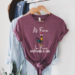 May include: A maroon t-shirt with a white graphic of a cartoon rooster with the text "It's Fine I'm Fine Everything Is Fine".