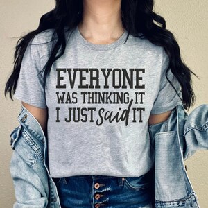 Pu&ograve; includere: Una maglietta grigia con il testo "Everyone was thinking it, I just said it" stampato in nero.