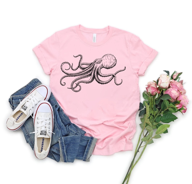 May include: A pink t-shirt with a black and white illustration of an octopus on the front.