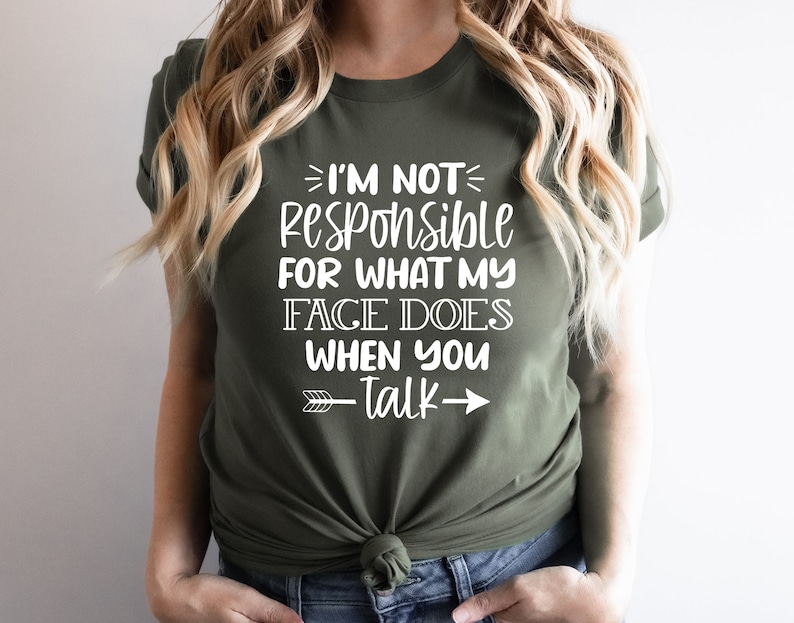 K&ouml;nnte beinhalten: Ein gr&uuml;nes T-Shirt mit wei&szlig;em Text, der "Ich bin nicht verantwortlich f&uuml;r das, was mein Gesicht tut, wenn du sprichst" lautet, mit einem wei&szlig;en Pfeil, der nach rechts zeigt.