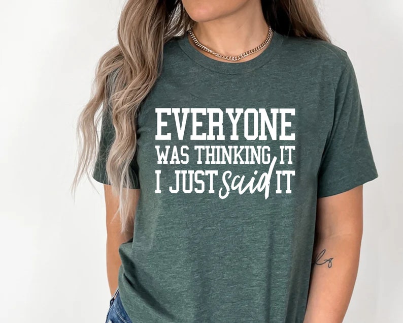 Pu&ograve; includere: Una maglietta verde scuro con il testo "Everyone was thinking it I just said it" in bianco.