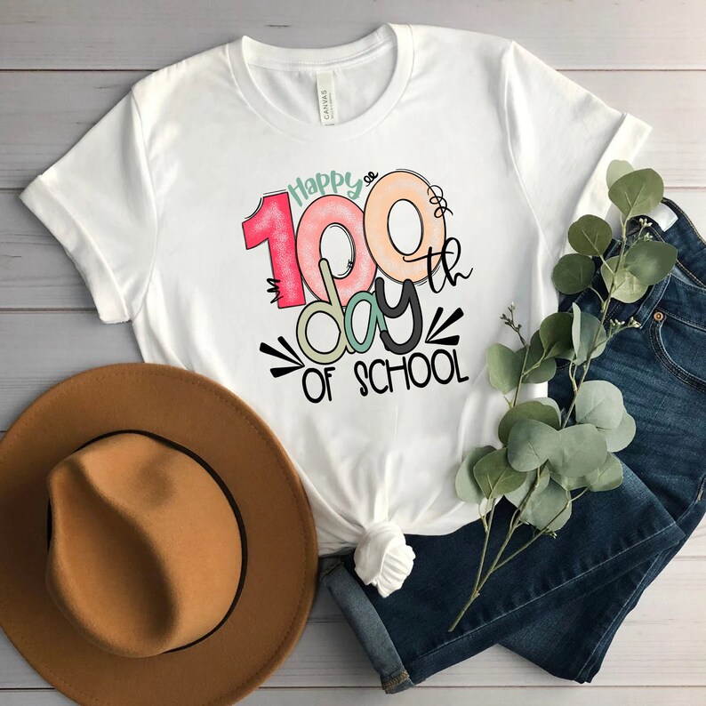 May include: White t-shirt with a colorful graphic that says "Happy 100th day of school".